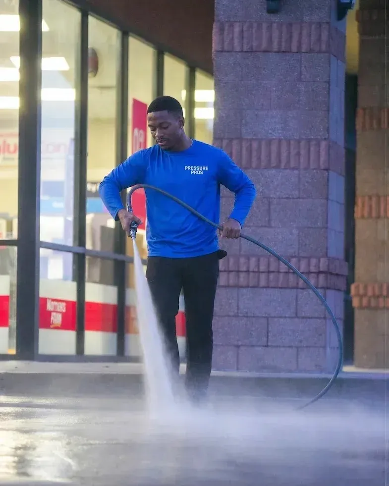 Pressure Pros team pressure washing a commercial parking lot exterior
